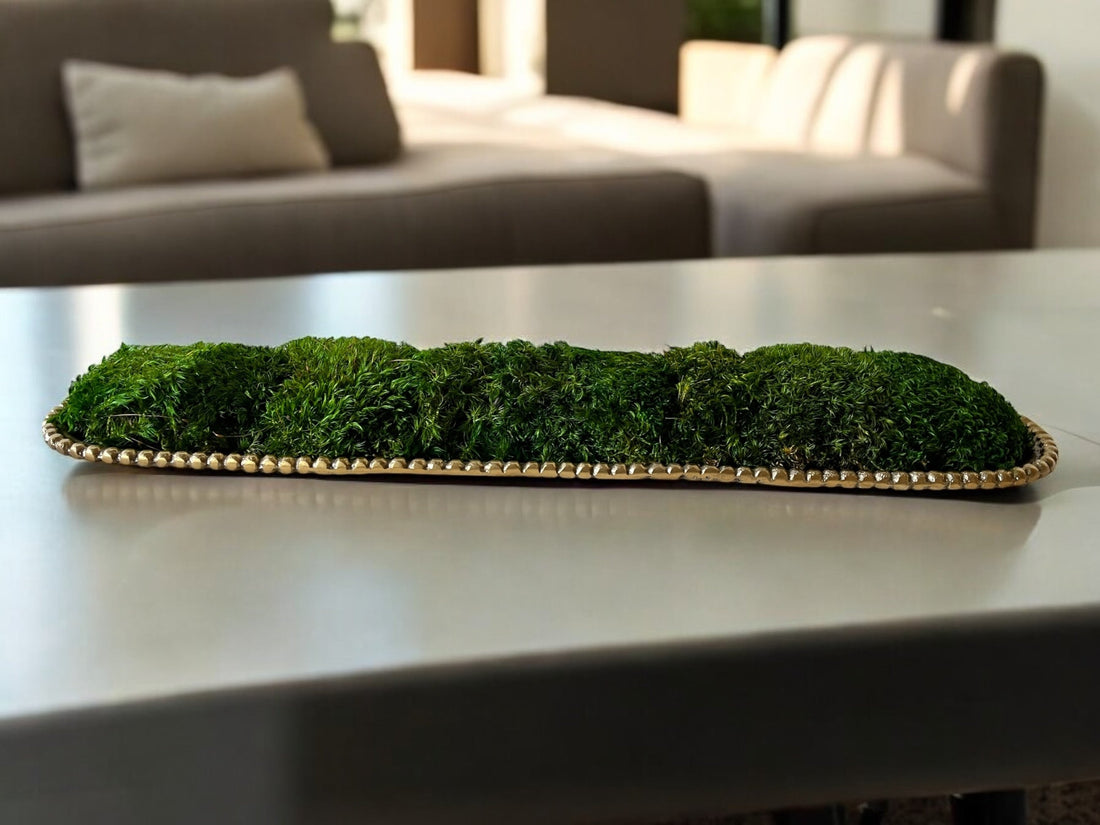 Long gold metal vessel filled with preserved moss running down a conference table